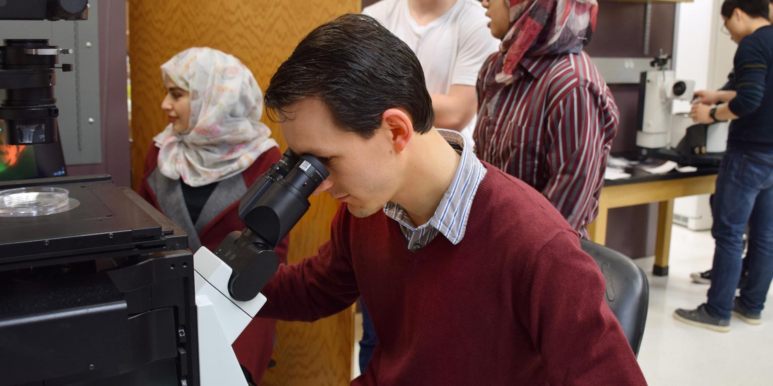 A student looks into magnifying equipment during a lab in Luddy Hall.